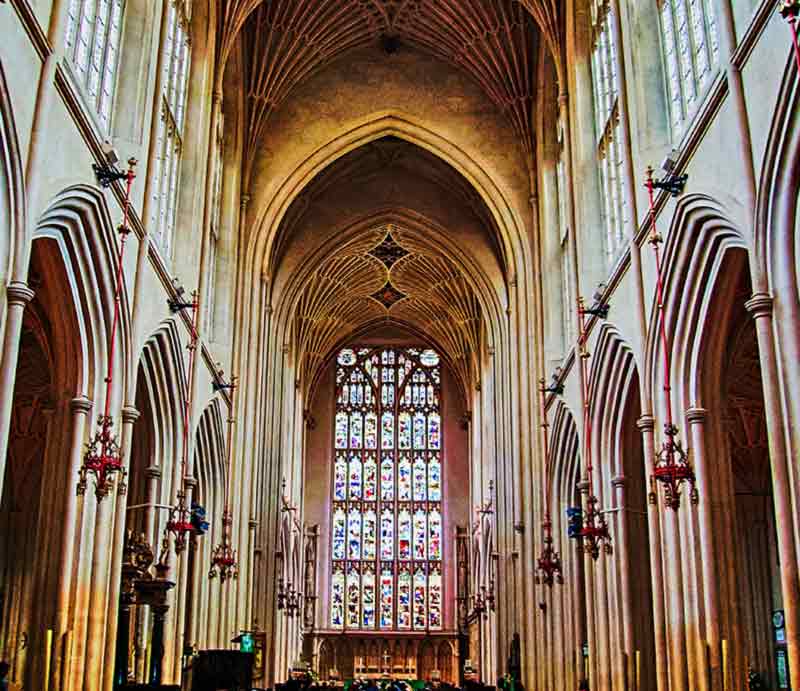 Large stained glass window and fan vaulted ceiling.