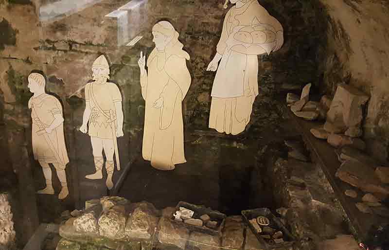 Stone built kitchen with 4 figures in medieval costume.